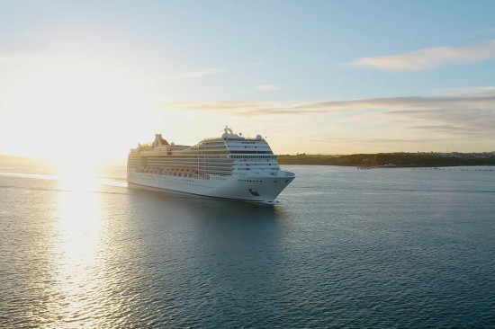 Gün ışığında kıyıya yaklaşan bir cruise gemisi
